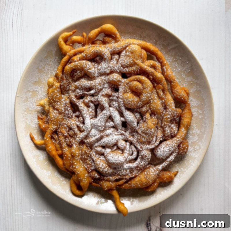 Delicious Funnel Cakes 12 funnel cakes on plate with powdered sugar