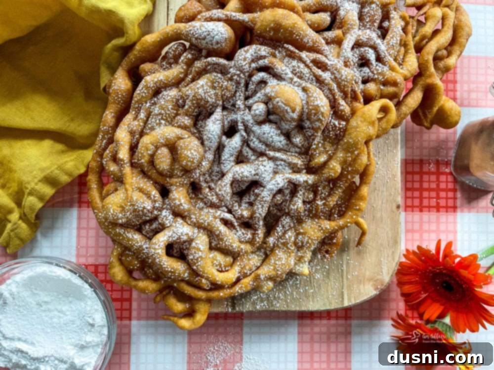 Delicious Funnel Cakes 15 funnel cake on wooden board with powdered sugar