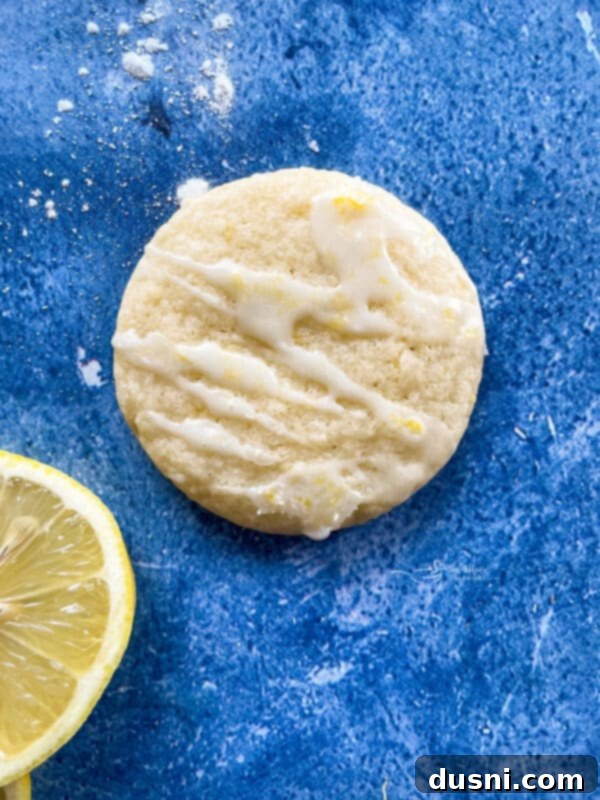 Sunshine Lemon Chewies 13 Lemon glaze being drizzled over warm cookies using a piping bag.