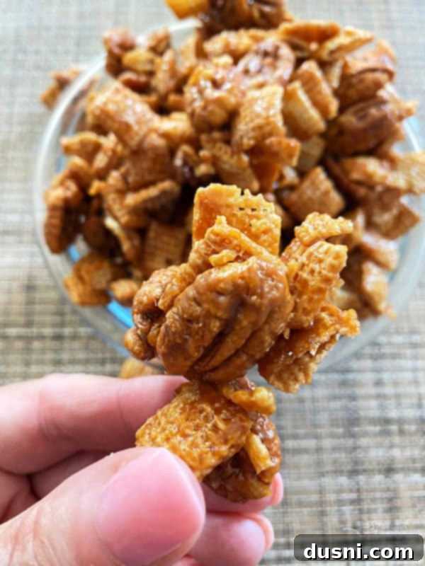 Close-up view of a pile of golden-brown caramel pecan clusters, showcasing their crunchy texture.