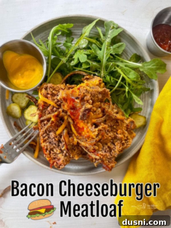 Bacon Cheeseburger Meatloaf, sliced and garnished with fresh pickles, on a serving platter