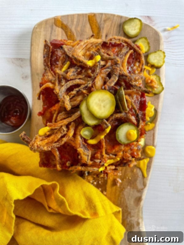 bacon cheeseburger meatloaf with fried onions and fresh pickles, served with a side salad