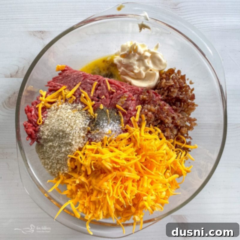 grated cheese, salt, pepper, breadcrumbs, ground meat, crumbled bacon, mayo, eggs, and mustard in a large mixing bowl