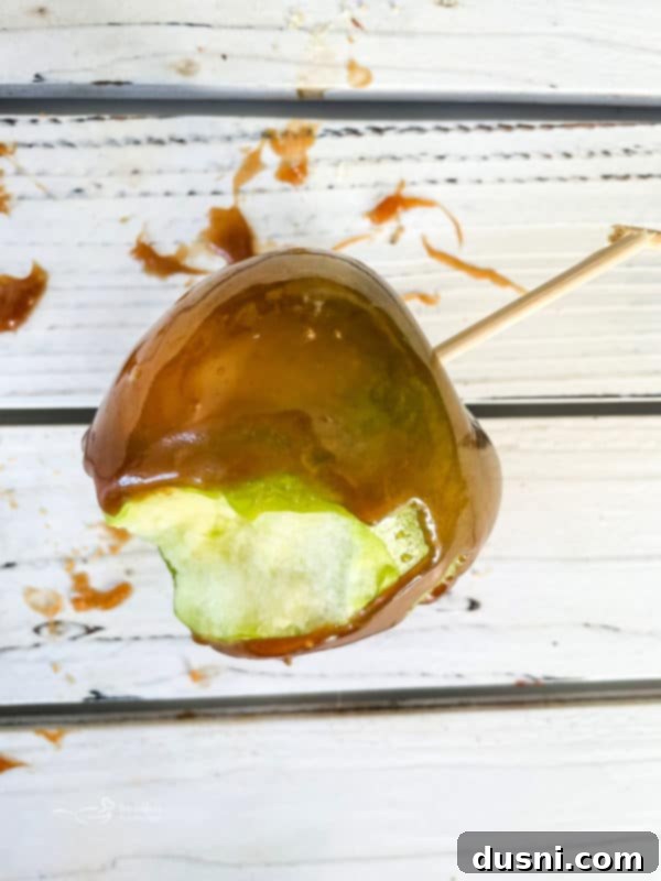 Crafting Golden Caramel Apple Treats 14 A homemade caramel apple on a cutting board, ready to be sliced