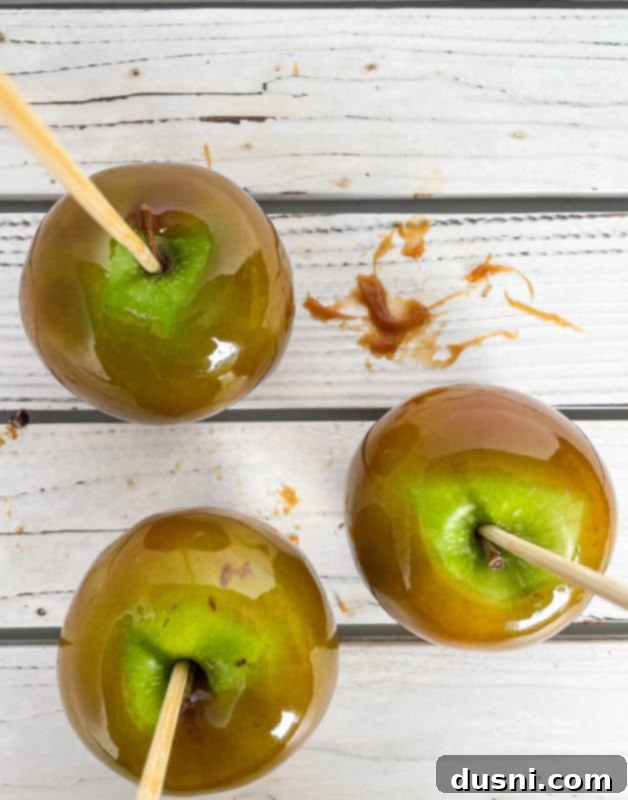 Crafting Golden Caramel Apple Treats 10 Freshly dipped caramel apples cooling on parchment paper