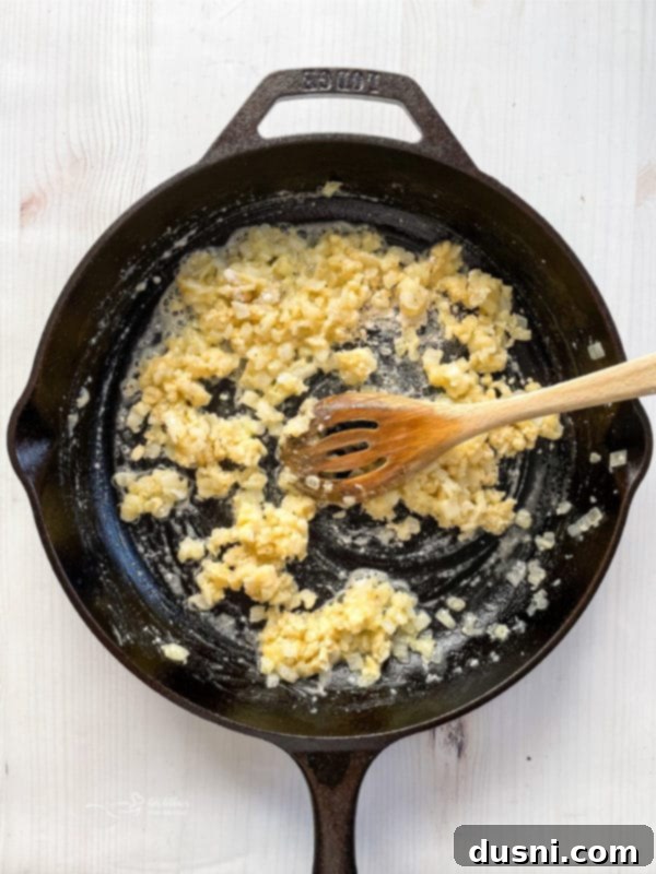 mixing flour and butter with onions and garlic in skillet with spoon