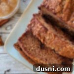 Spiced Applesauce & Dark Chocolate Loaf 5 one loaf of applesauce bread on white plate with applesauce in bowl