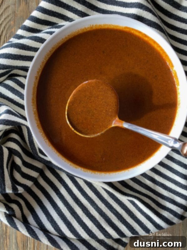 Whisking ingredients for red enchilada sauce in a saucepan