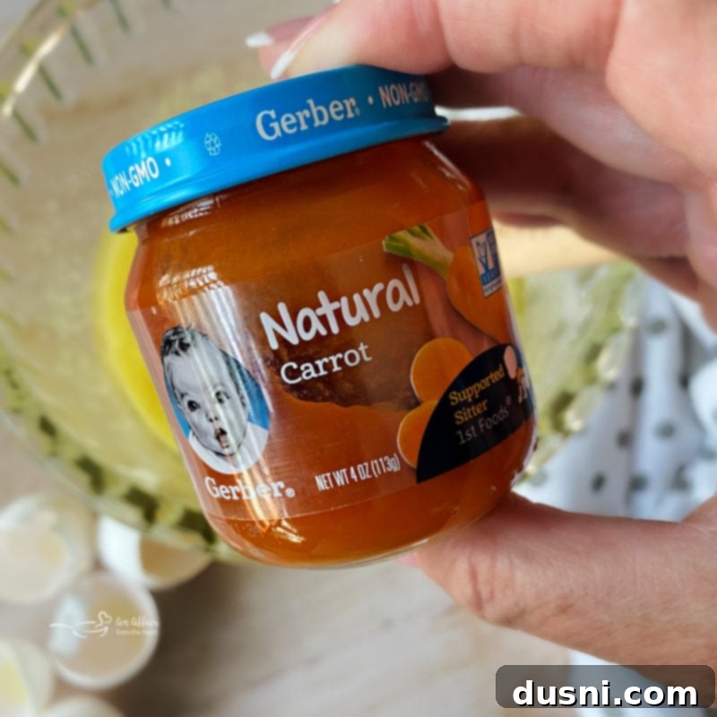 Carrot Cake Bars A single jar of puréed baby food carrots, highlighted as the secret ingredient for extra moisture and flavor in the carrot cake bars.