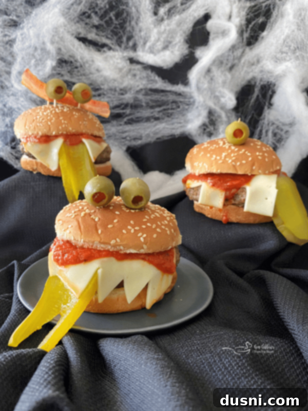 Rebel Shirley Float 12 Monster Burgers for Halloween - 3 burgers with black buns and olive 'eyes' on a webbed background