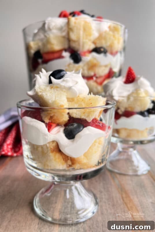 Close-up of a Berry Trifle layer, showing fresh blueberries and red raspberries over whipped cream.