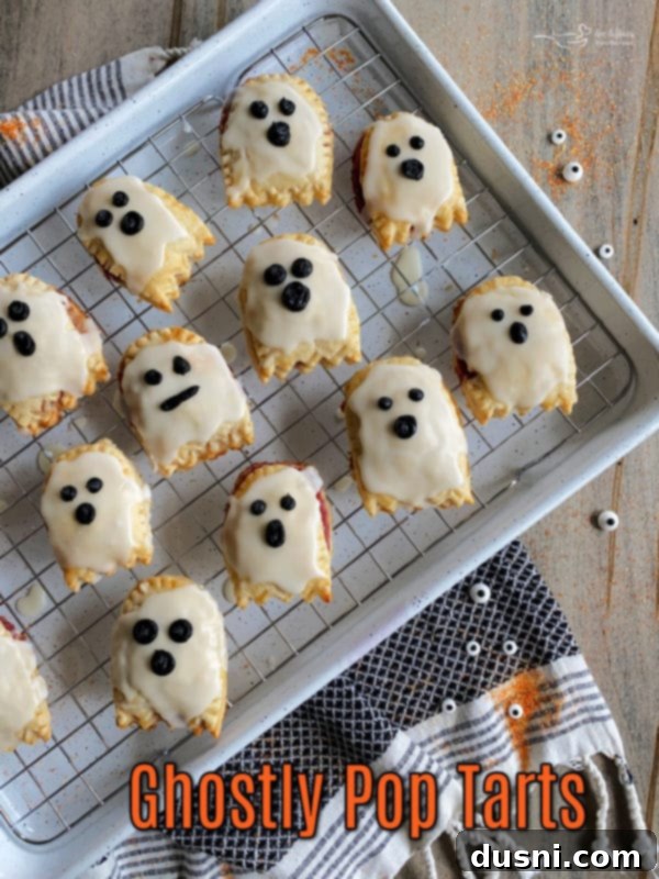 Adding the eyes and mouth to ghost pop tarts with black decorator icing