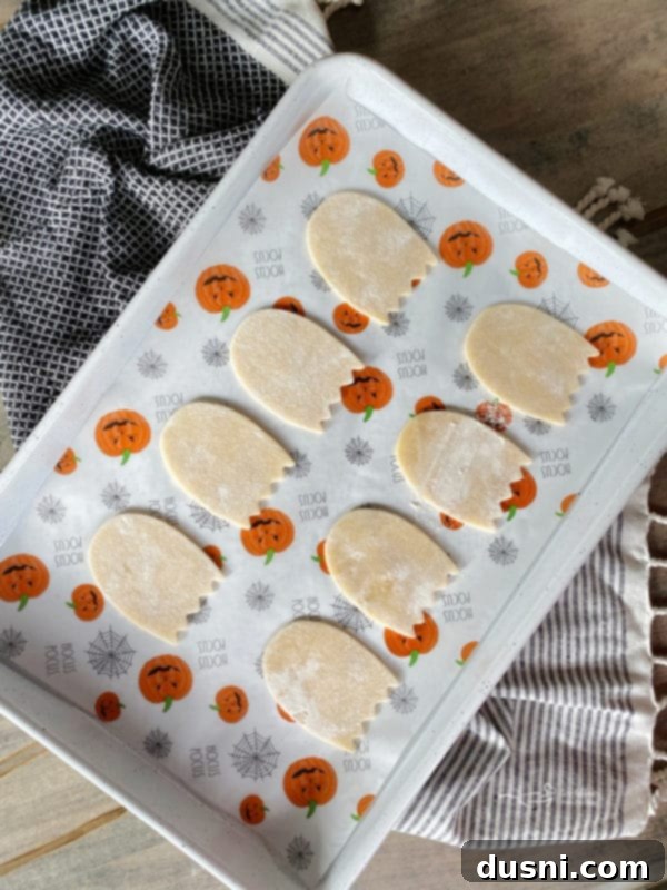 Arranging pop tart ghost cutouts on a baking sheet