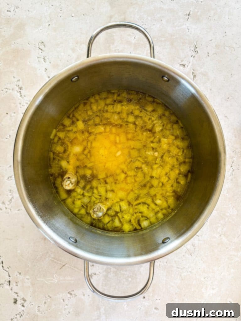 Soul-Soothing Chicken Noodle Soup 7 Close-up of a pot of homemade chicken noodle soup simmering on a stove, with the lid slightly ajar, steam gently rising.