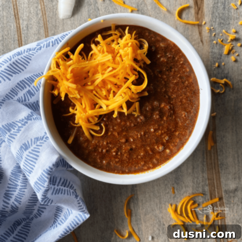 Homemade Cincinnati Chili, Skyline Style 4 Bowl of Cincinnati chili covered with a generous layer of shredded cheese