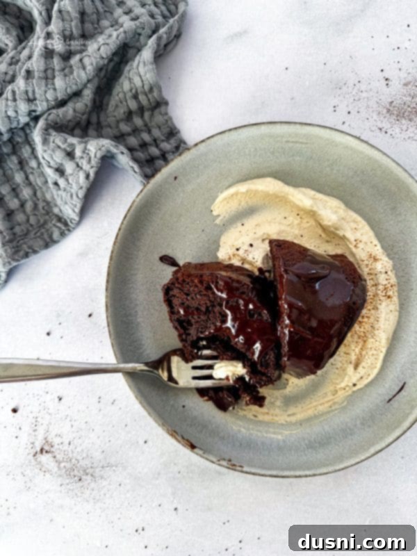 Velvet Espresso Chocolate Torte 2 A slice of chocolate espresso cake on a white plate with a fork.