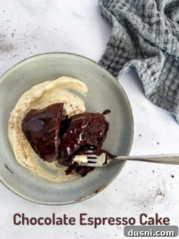 Velvet Espresso Chocolate Torte 17 A slice of chocolate espresso cake on a plate, with the full cake in the background.