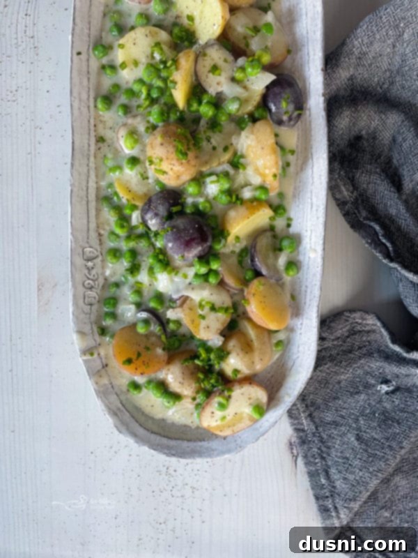 A dish filled with creamy new potatoes and peas, ready to be served.