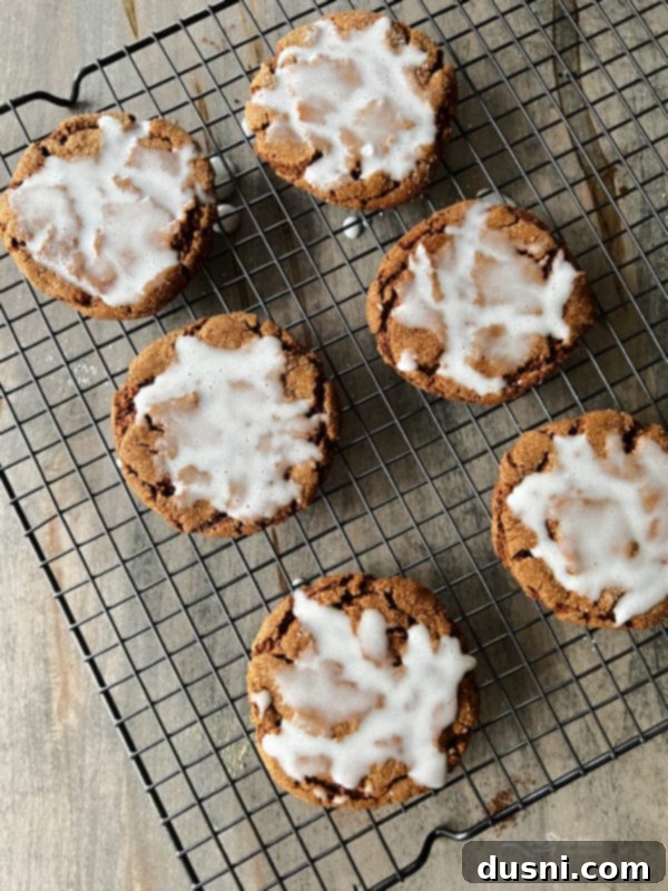 Chewy Ginger Crinkle Cookies Iced molasses cookies with their glaze perfectly set, resting on a wire rack, ready for storage or immediate enjoyment.
