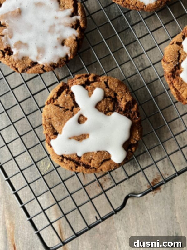 Molasses Cookies with Icing Recipe Close-up of freshly iced molasses cookies cooling on a wire rack, with the white glaze enhancing their crinkled surface.