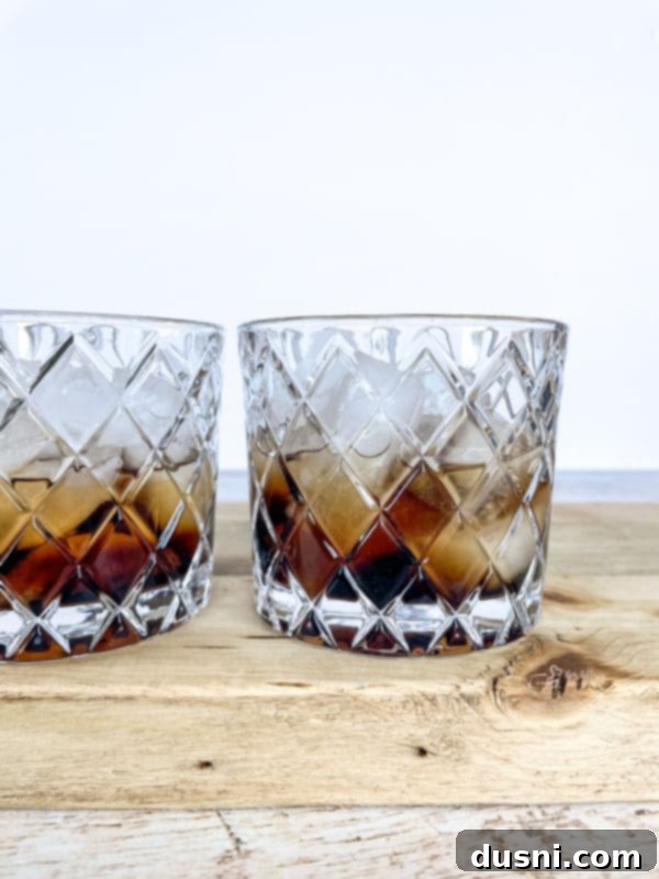 Velvet Pumpkin White Russian 6 A hand adding vodka to a glass already containing Kahlua and ice for a Pumpkin White Russian.