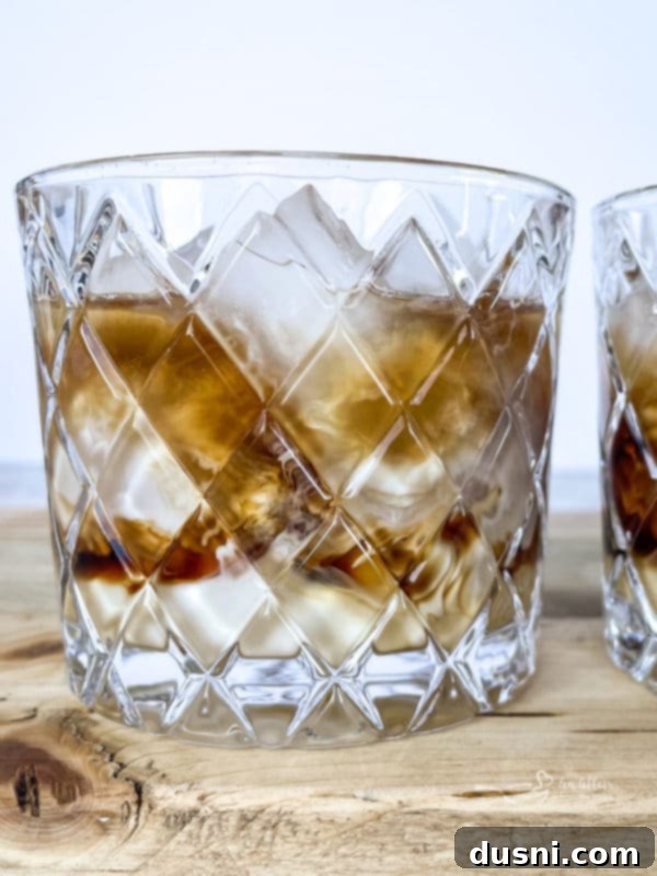 Velvet Pumpkin White Russian 8 A close-up of a completed Pumpkin White Russian cocktail, with visible layers and a sprinkle of pumpkin pie spice on top, ready to be enjoyed.