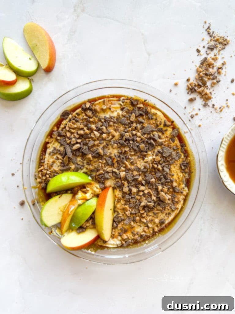 A delicious Caramel Apple Dip with cream cheese and Heath Bar pieces, served with fresh apple slices.