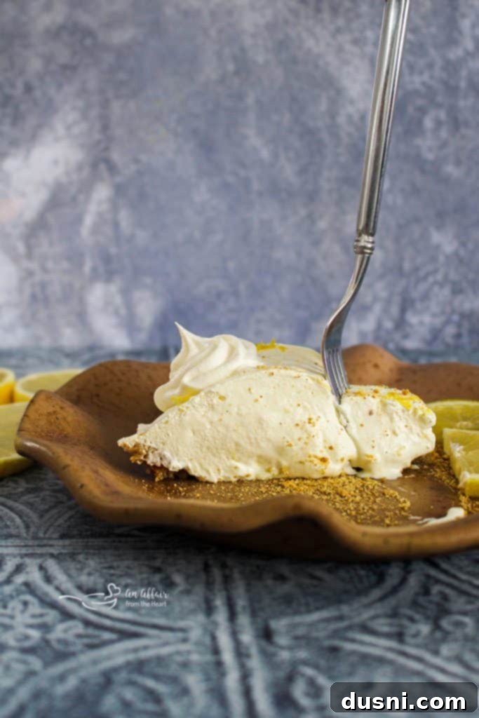 Effortless Lemon Dream Pie 14 Pinterest pin graphic for Lemon Icebox Pie, featuring a beautiful image of the pie.