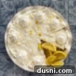 Effortless Lemon Dream Pie 19 Lemon Icebox Pie with lemon wedges in the missing slice area.