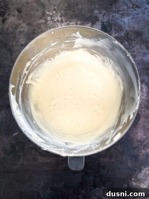 Luxurious White Chocolate Raspberry Truffle Cheesecake 14 Beating cream cheese and sugar for cheesecake filling