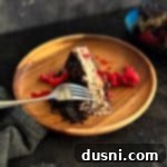 Luxurious White Chocolate Raspberry Truffle Cheesecake 27 Slice of White Chocolate raspberry cheese cake on a wood plate