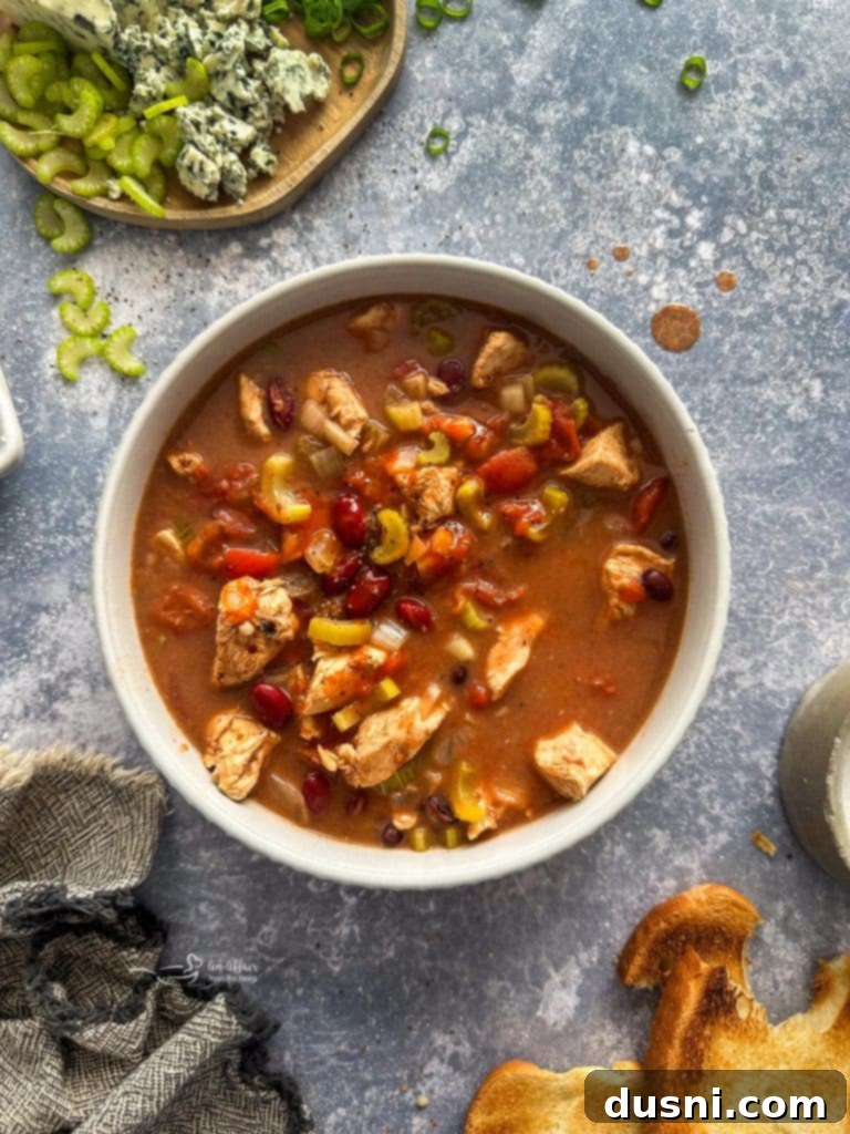 Hearty Slow Cooker Buffalo Chicken Chili 6 All the raw ingredients for Slow Cooker Buffalo Chicken Chili, including chicken, vegetables, beans, and hot sauce, in a slow cooker before cooking.