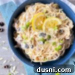 one bowl filled with pasta, tuna, mushrooms, olives, and lemon