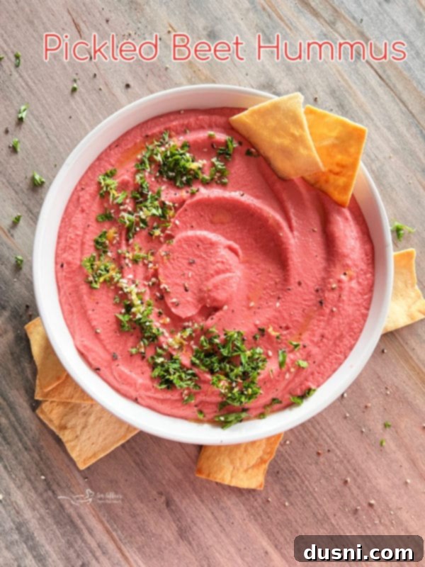 white bowl with pink hummus and crackers