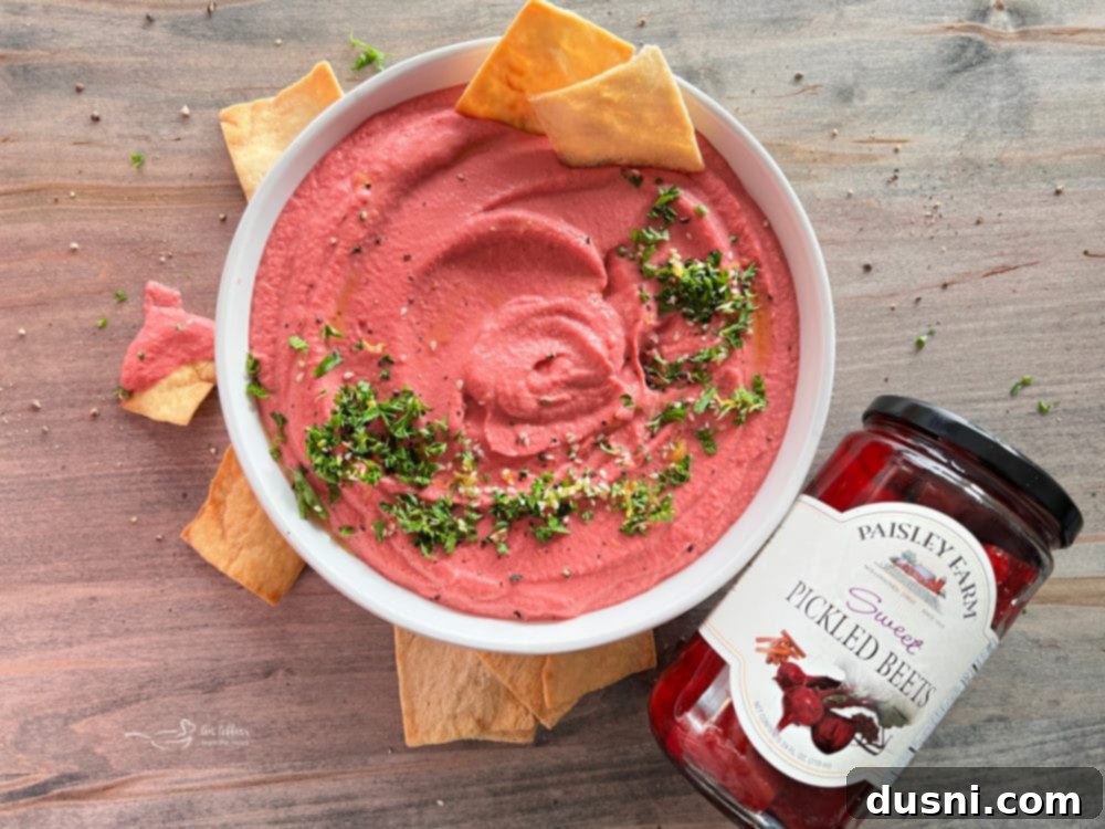 pickled beet hummus with parsley and chips next to jar of pickled beets