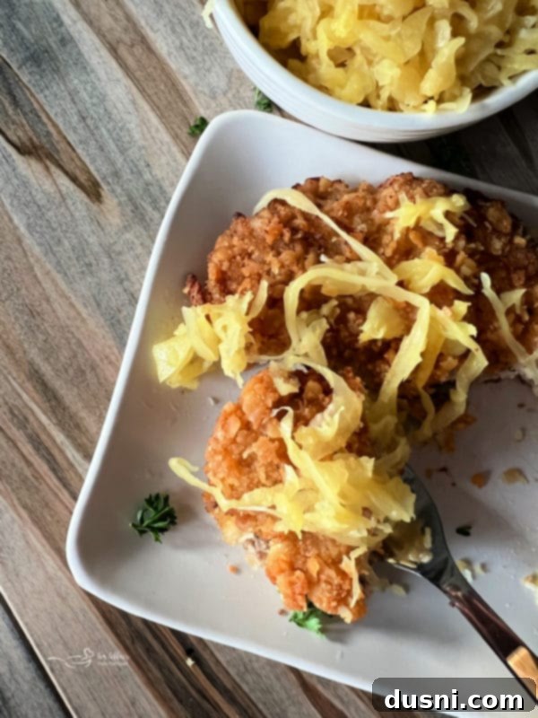 A breaded pork cutlet on a plate with Frank's Mustard Kraut and a lemon wedge.