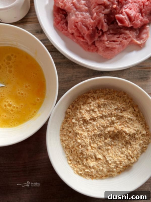 Raw breaded pork cutlets ready to be pan-fried.