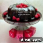 Decadent Dark Chocolate Raspberry Dream with Clotted Cream 2 Chocolate Bliss Cake with Raspberry Sauce and Devonshire Cream on a cake plate