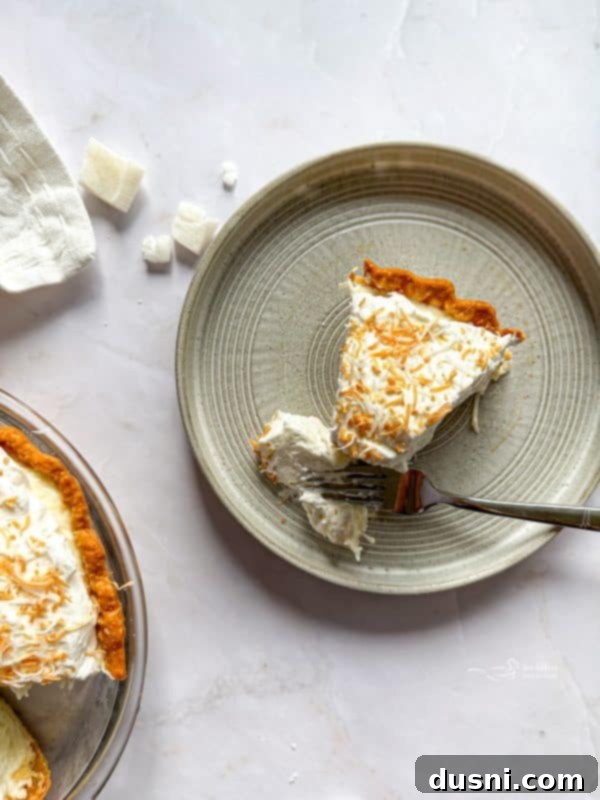 Whole Coconut Cream Pie garnished with whipped cream and toasted coconut
