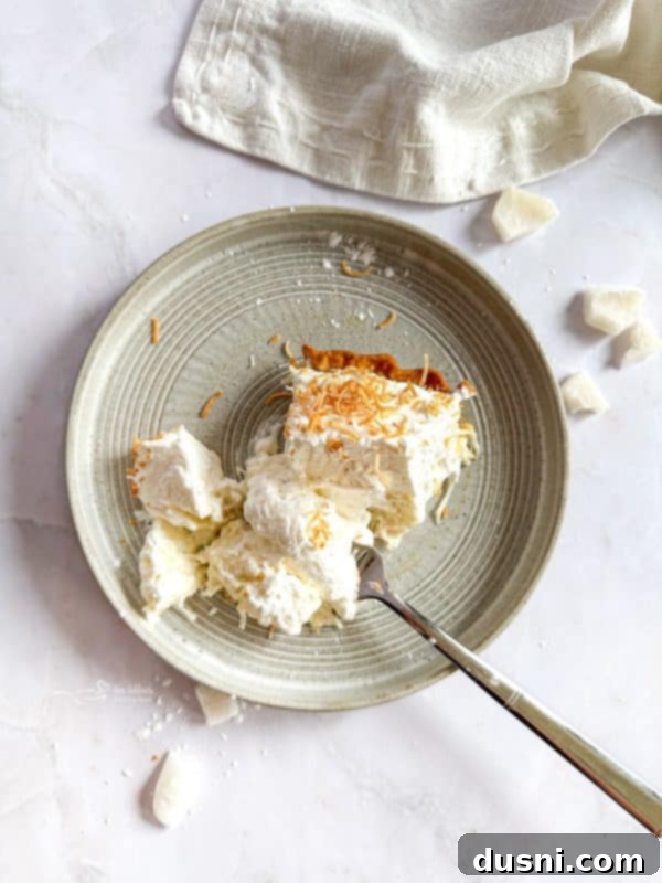 Slice of Coconut Cream Pie with a fork, showing the creamy texture