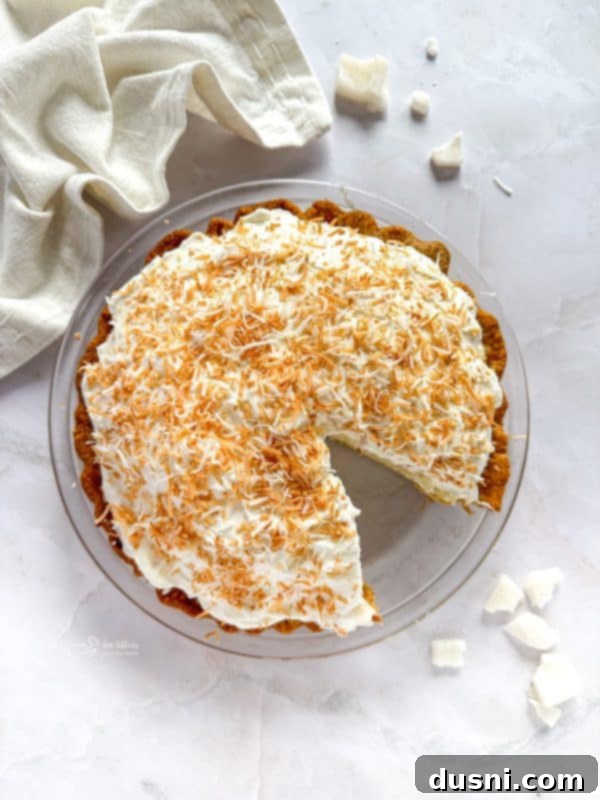 Whole Coconut Cream Pie on a stand, ready to serve
