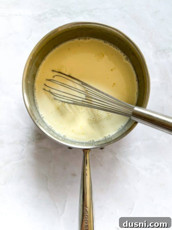 Step-by-step image: combining custard ingredients in a saucepan