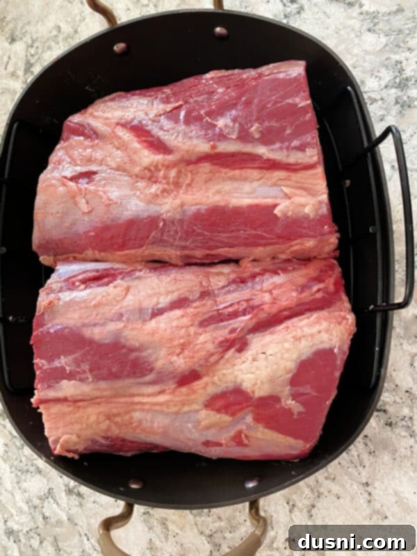 Prime rib roast being placed into an ungreased roasting pan, fat side up