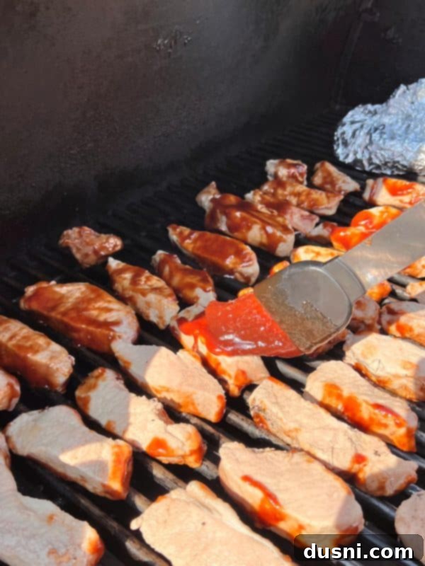 BBQ pork ribs caramelizing on the grill, brushed with sauce