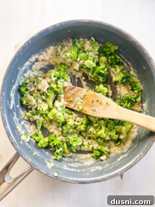 Broccoli Stuffed Mushroom Caps Broccoli florets and flour being added to a pan with sautéed mushroom stems and onion, enhancing the filling.
