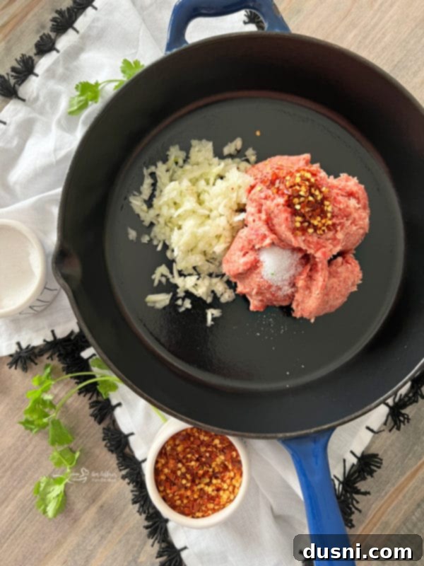Sausage and onion browning in a skillet