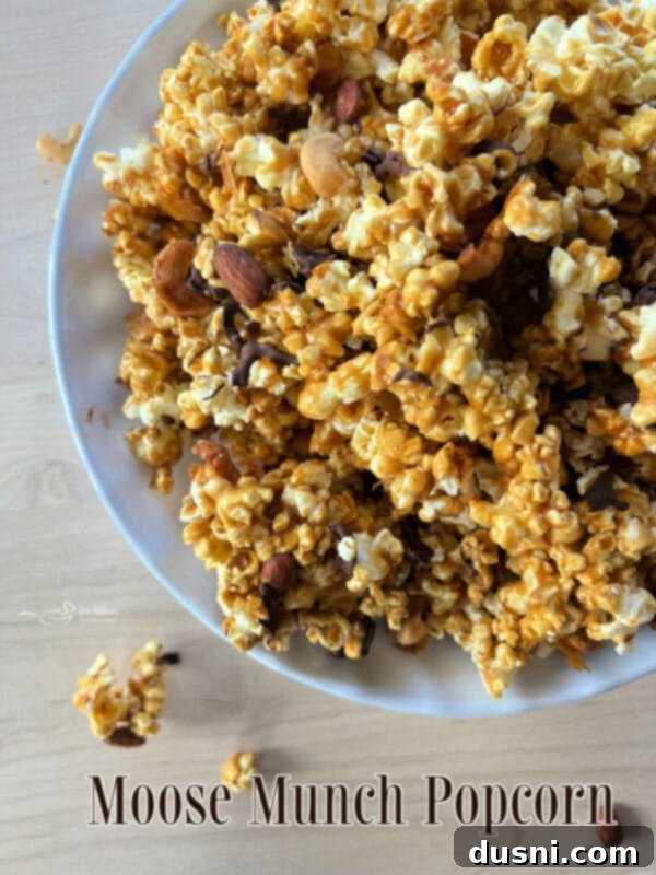 Moose Munch Popcorn in a bowl, a copycat recipe for a chocolate and caramel-coated popcorn with almonds and cashews.