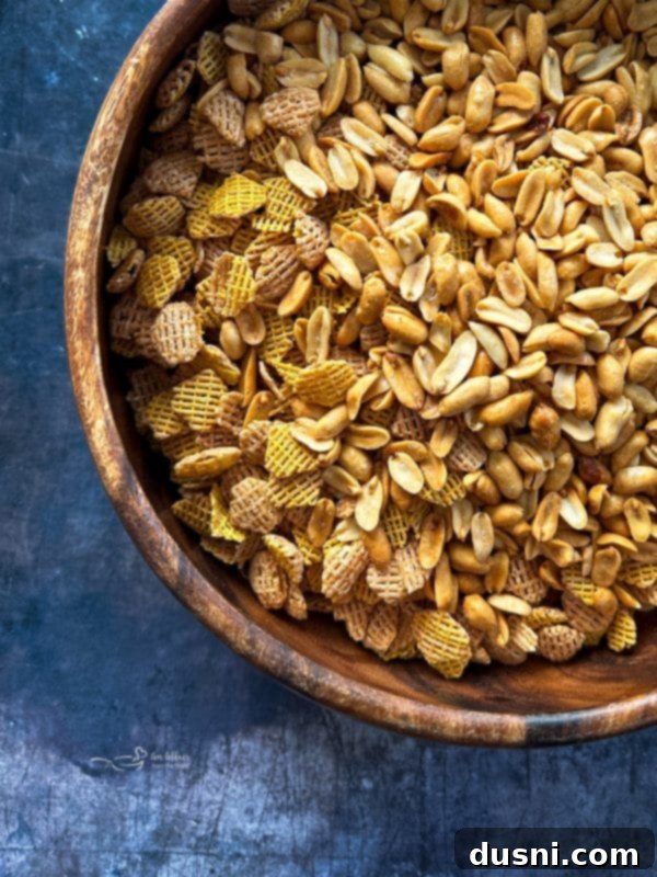 Crispix cereal and peanuts in a large mixing bowl, ready for the caramel coating.