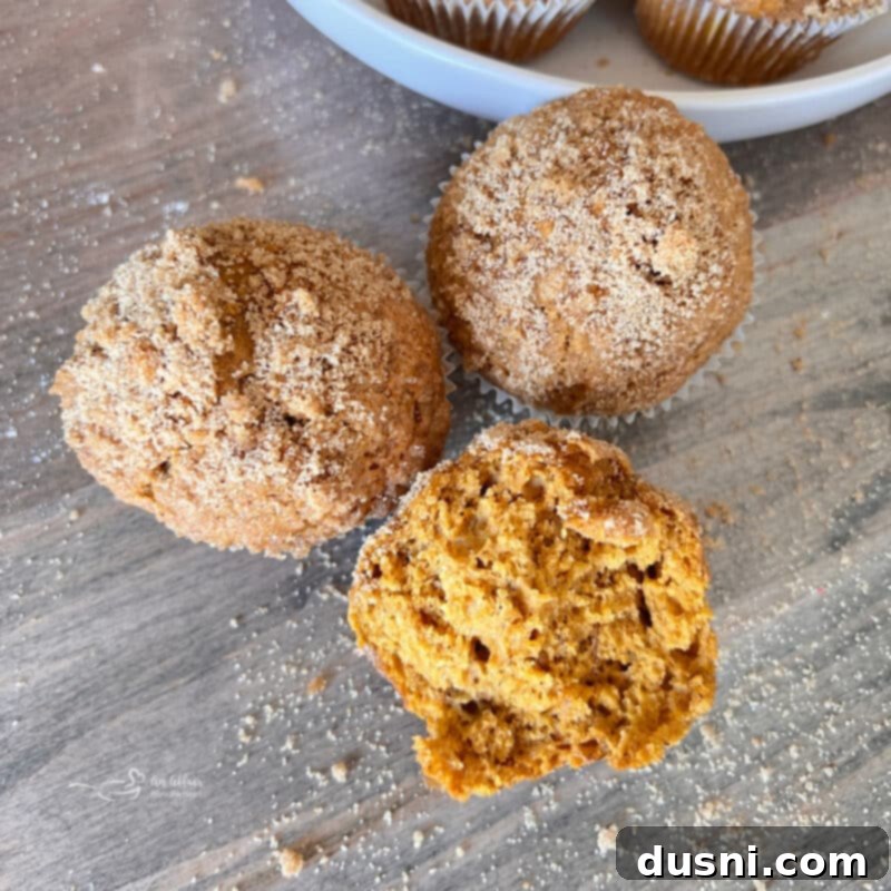 Autumn Spiced Banana Pumpkin Muffins 4 A trio of freshly baked Pumpkin Spice Banana Muffins on a cooling rack, highlighting their perfect golden tops