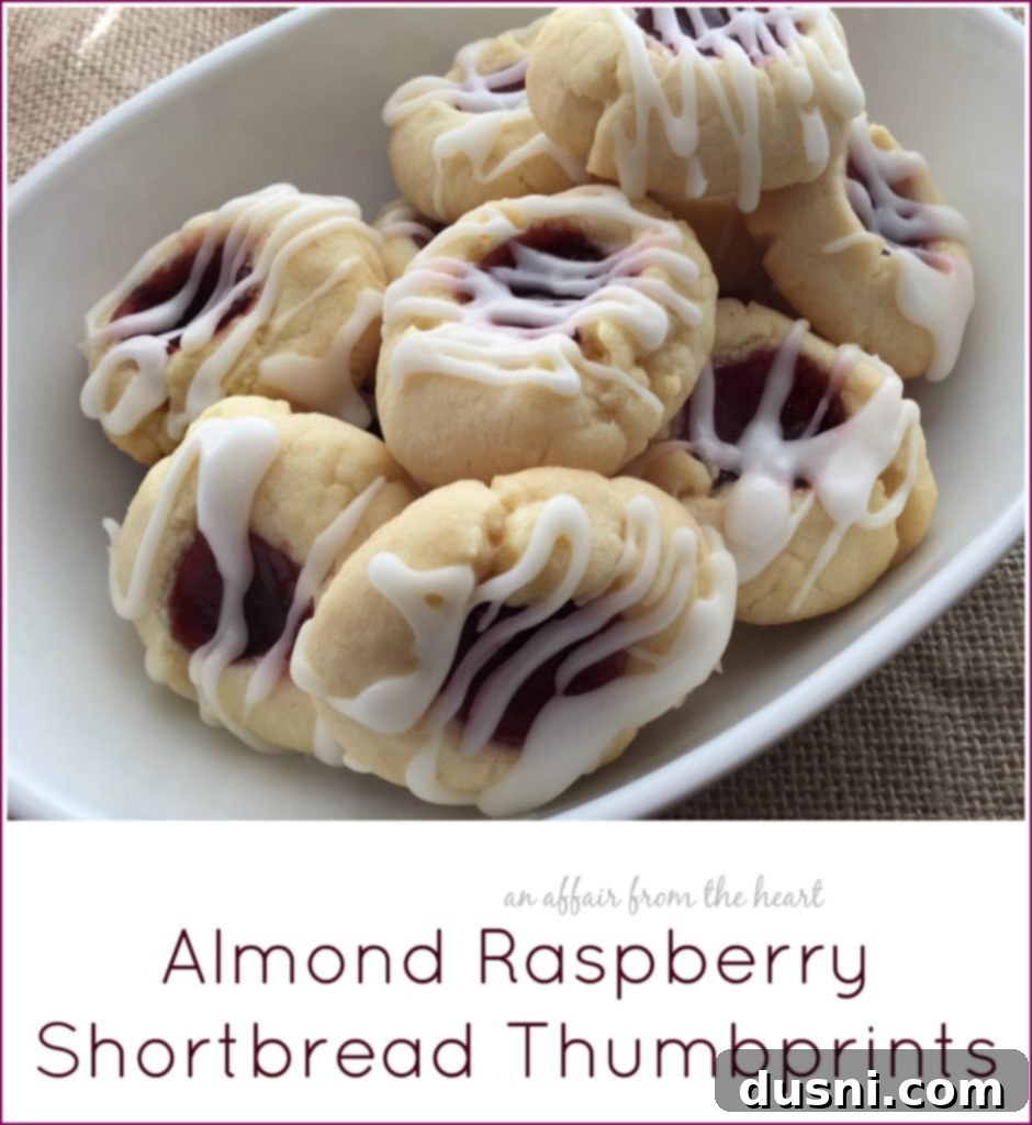 Raspberry Almond Shortbread Jewels 21 A stack of almond raspberry shortbread thumbprints on a white plate with a decorative fork